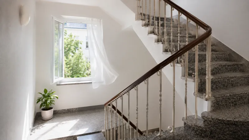 Helles Treppenhaus mit geöffnetem Fenster zum Lüften